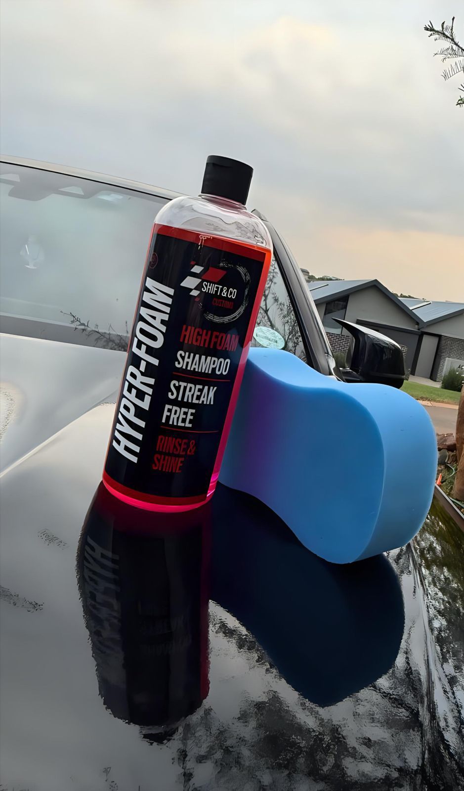 Car care product with bottle and blue foam block on a car window