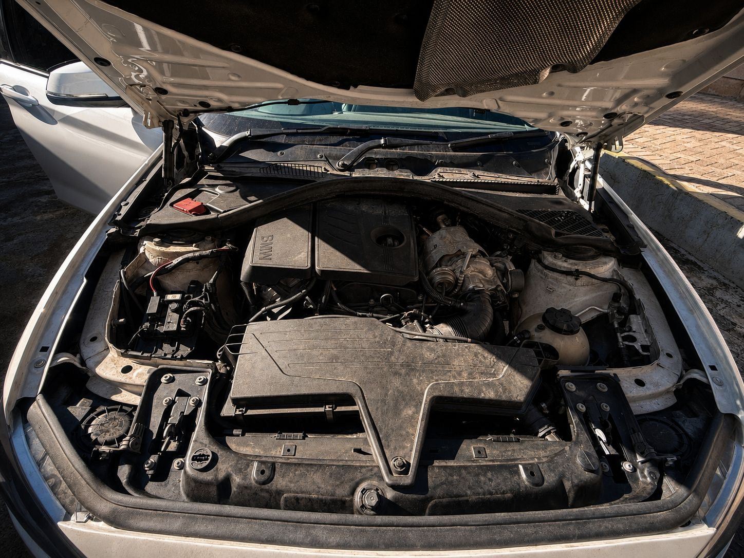 Open car hood revealing the engine compartment.