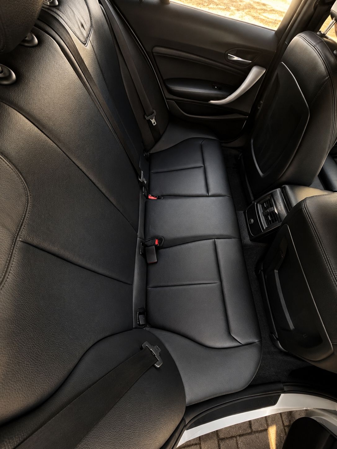 Close-up of black car interior with visible seat and door panel.
