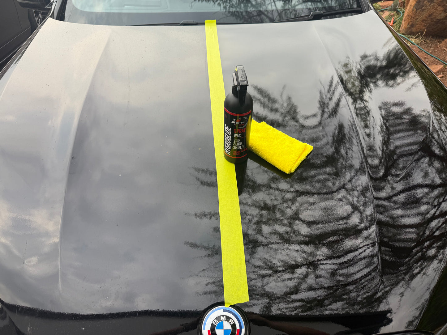 Car with a yellow tape measure and cleaning tool on a hood