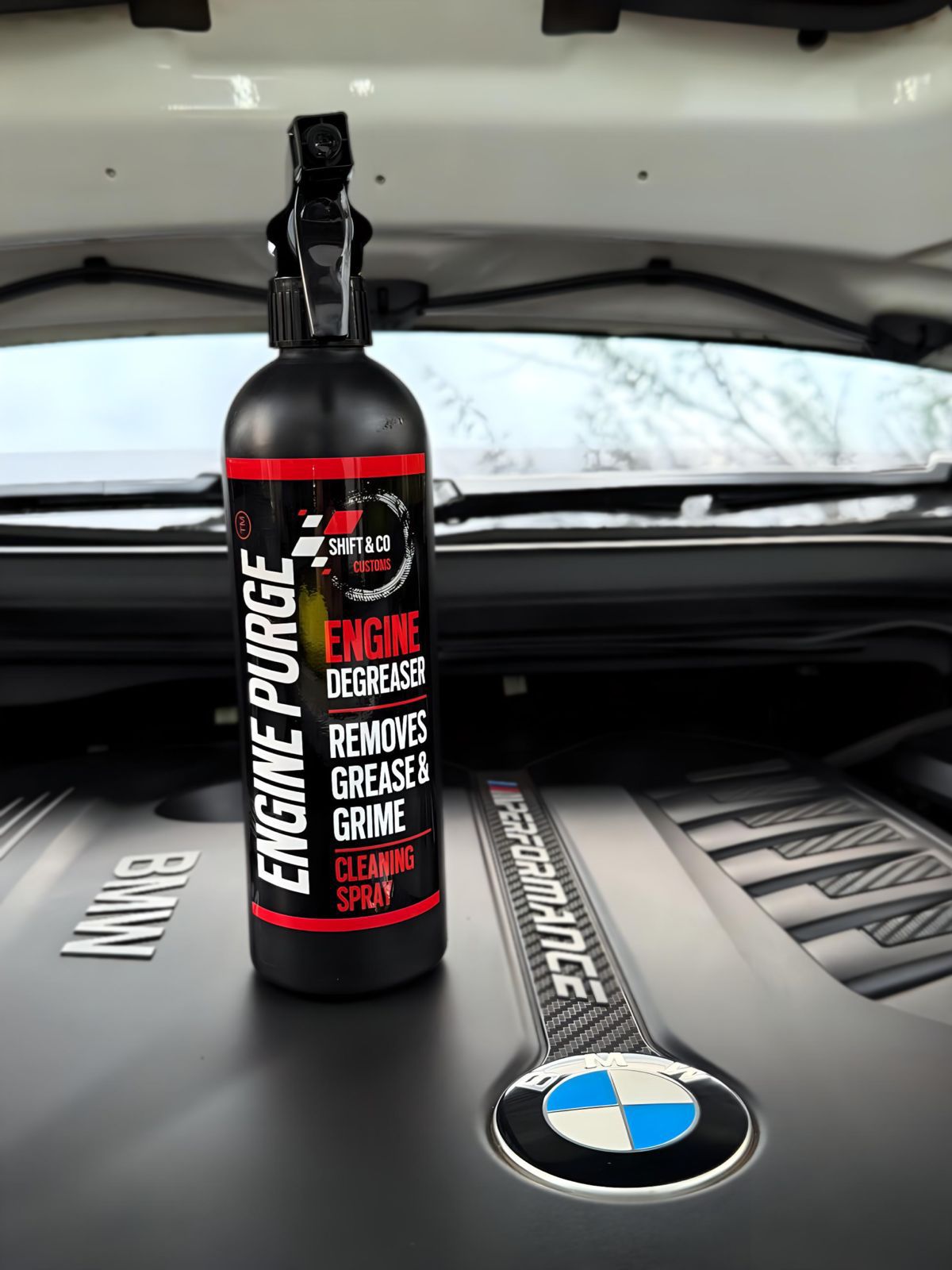 Engine degreaser spray bottle on a car's engine bay with a BMW logo.