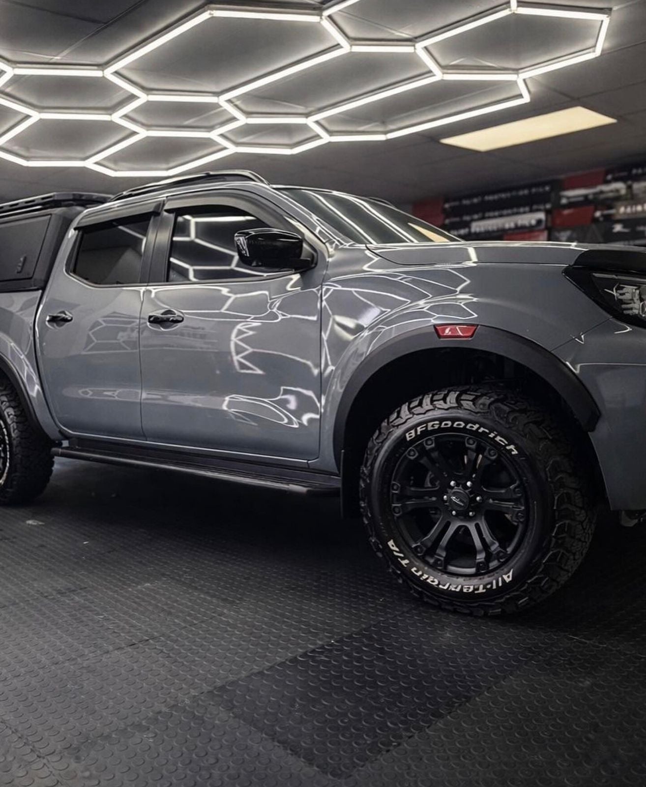 Gray pickup truck in a showroom with geometric ceiling lights
